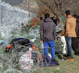 Flüchtlinge auf der Balkanroute vor einem Grenzzaun (Archiv), via