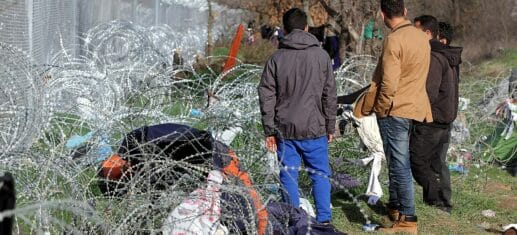 Flüchtlinge auf der Balkanroute vor einem Grenzzaun (Archiv), via 