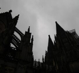 Kölner Dom dunkel unter grauen Wolken (Archiv), via