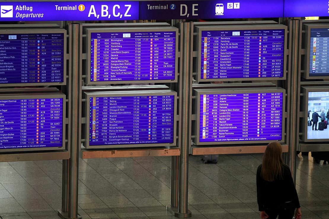Frau vor Informationstafel am Frankfurter Flughafen