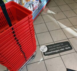 Einkaufskörbe mit Corona-Hinweis in Supermarkt (Archiv)